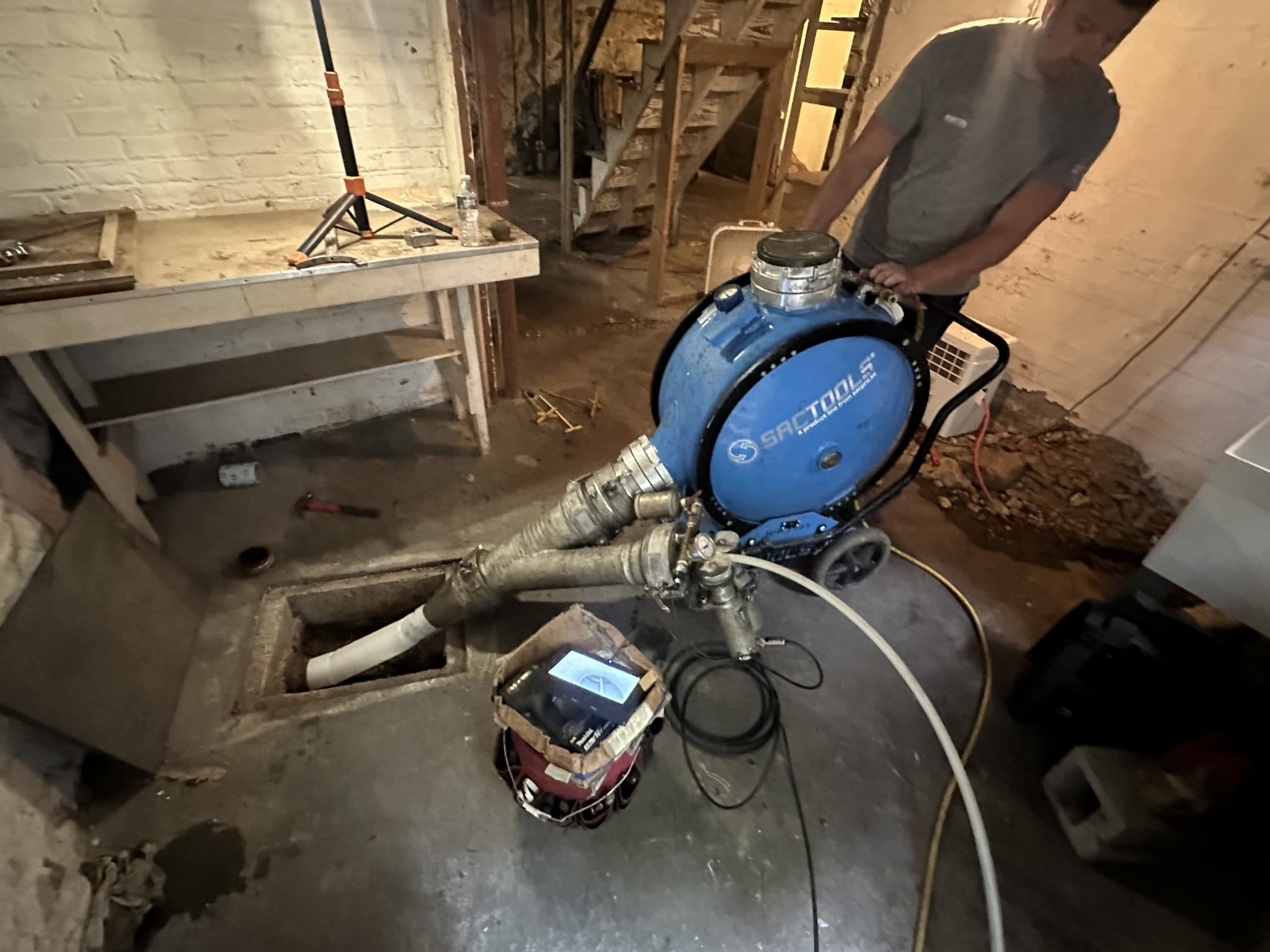 Lining equipment and monitor beside an accessible basement sewer opening