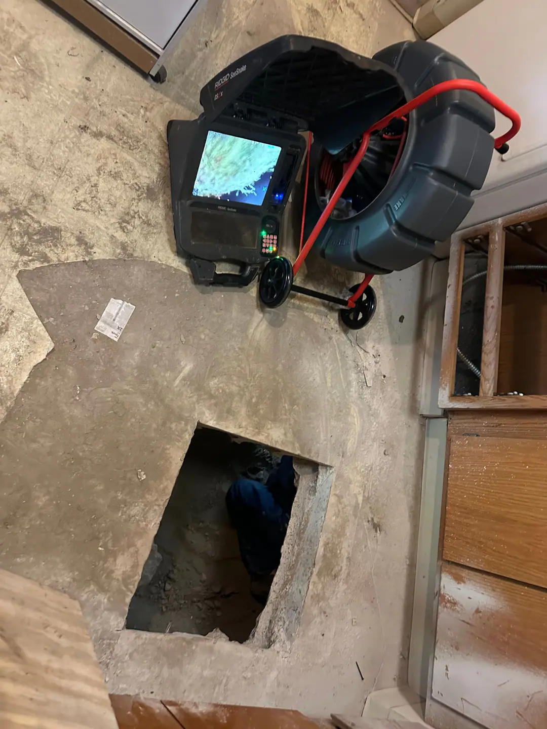 Our camera reel and monitor beside an opening in a concrete floor on our Back Bay job