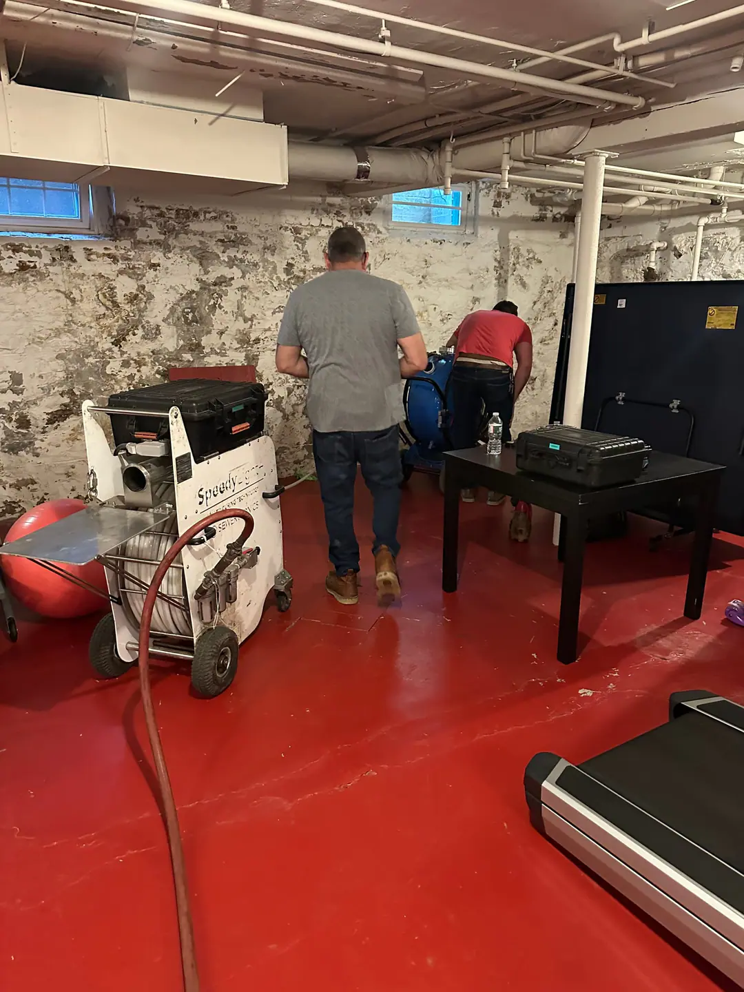Our crew setting up lining equipment in a basement on our Back Bay job