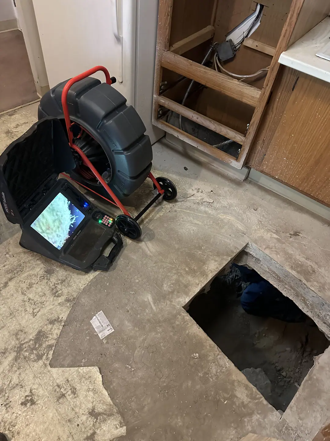 Camera reel and monitor beside an opening in a concrete floor on our Back Bay job