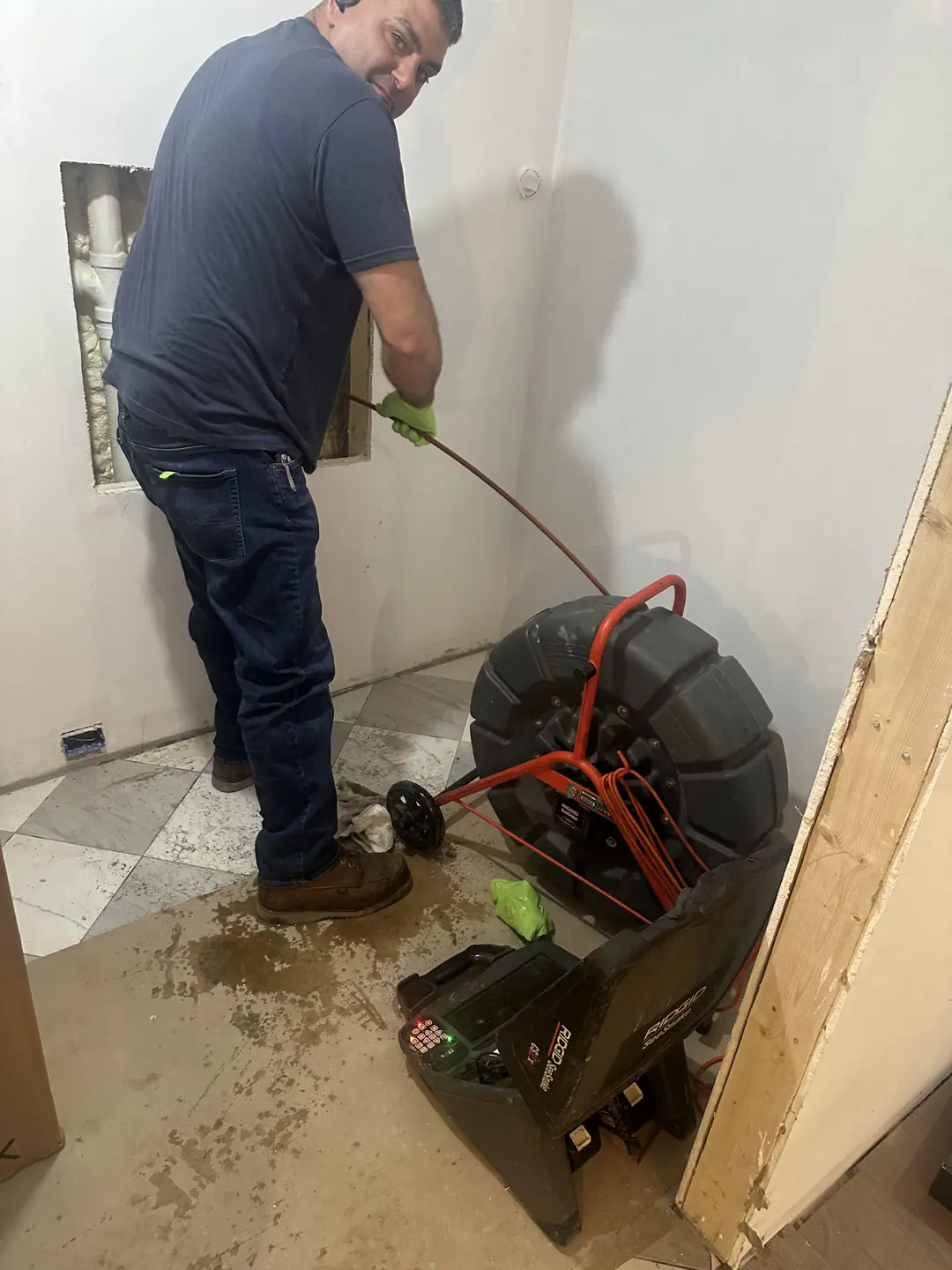 Technician feeding an inspection camera cable into an accessible drain