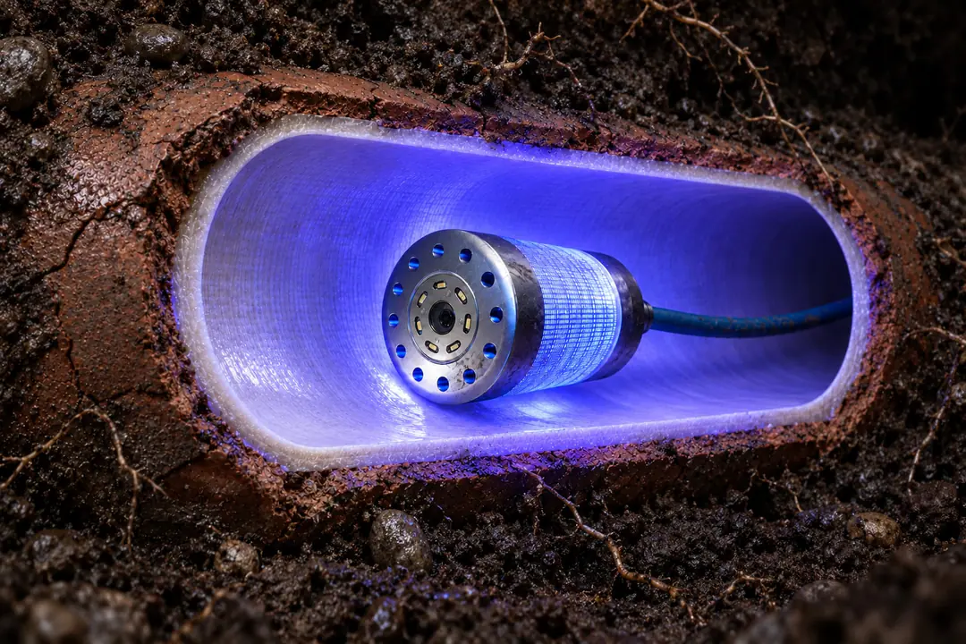 Rendering of a buried sewer with a UV curing head lighting the new liner in bright blue-violet light