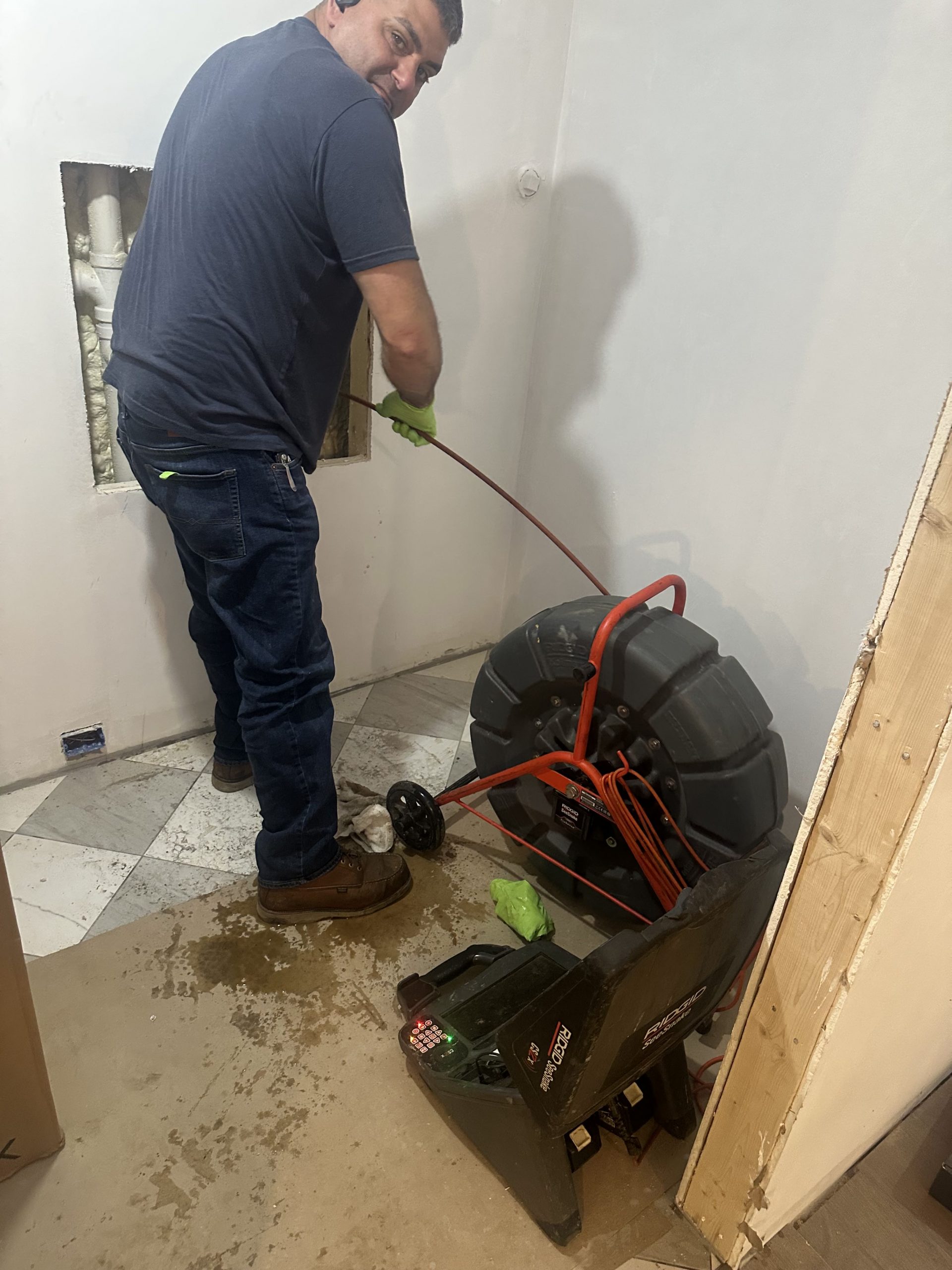 Boston Pipelining crew performing trenchless sewer repair setup inside basement