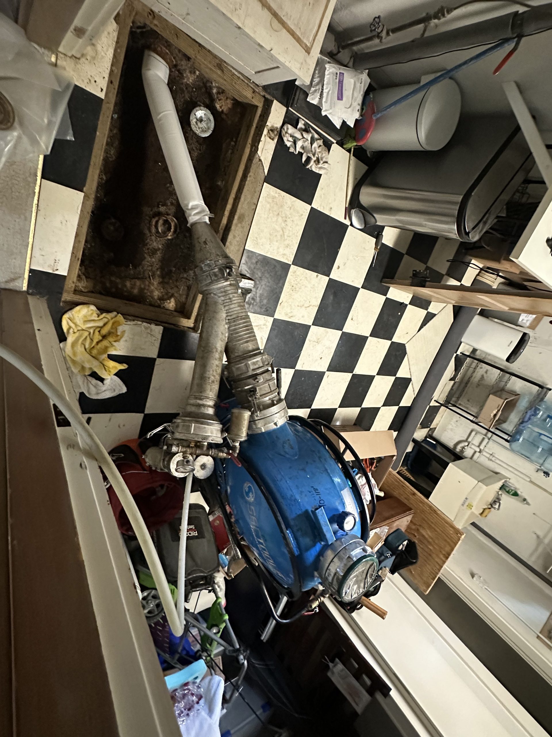 Trenchless repair team operating UV cure equipment in basement